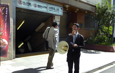 石坂わたるの活動: 中野坂上駅での『たつのこ通信』の配布と区政の報告の様子
